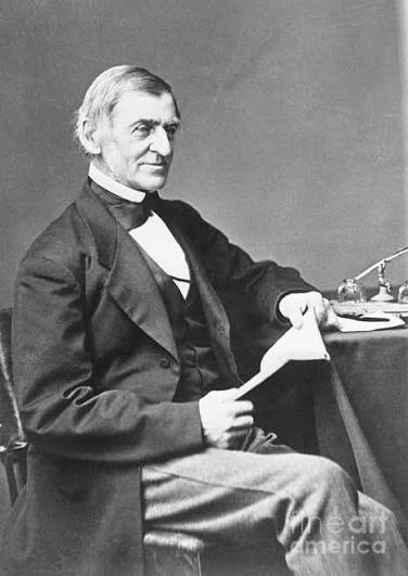 A photograph of the poet, Ralph Waldo Emerson, who is seated at a desk holding papers. Getty Image
